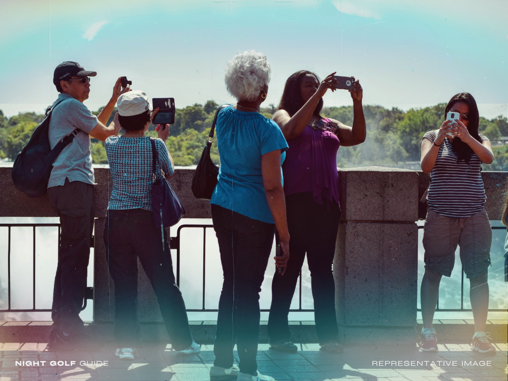 Tourist taking pictures at a night golf location with LED lights and city skyline