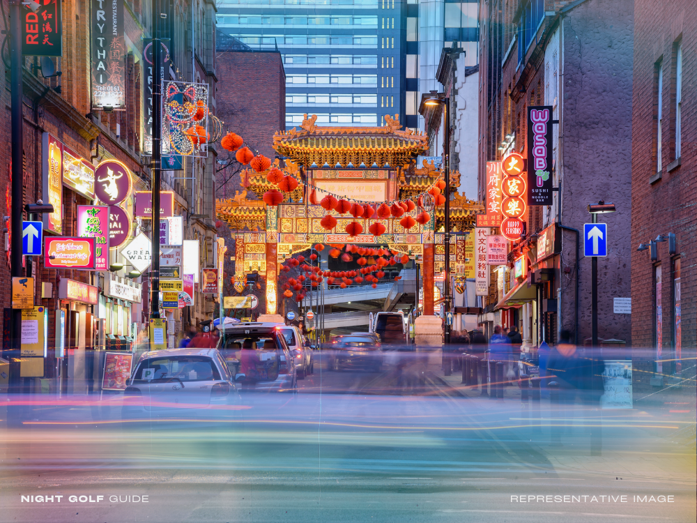 Asian urban street at night with lit restaurants and stalls