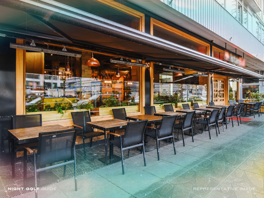 Outdoor seating at a modern restaurant patio after night golf