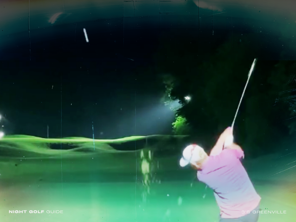 Group of golfers playing under lights at 3's Greenville at night