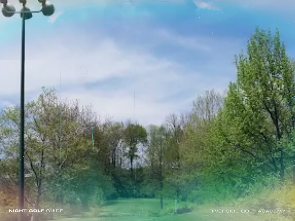 Evening golf practice at Riverside Golf Academy with illuminated range and golfers mid-swing